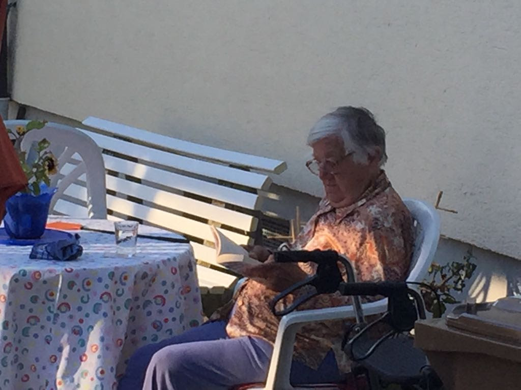 Una mujer lee en el patio de su vivienda